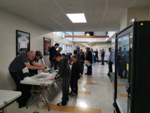 People are lined up to register their robots and get them checked for weight and height restrictions.