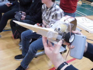 A robot with googley eyes and a large beak of wood.