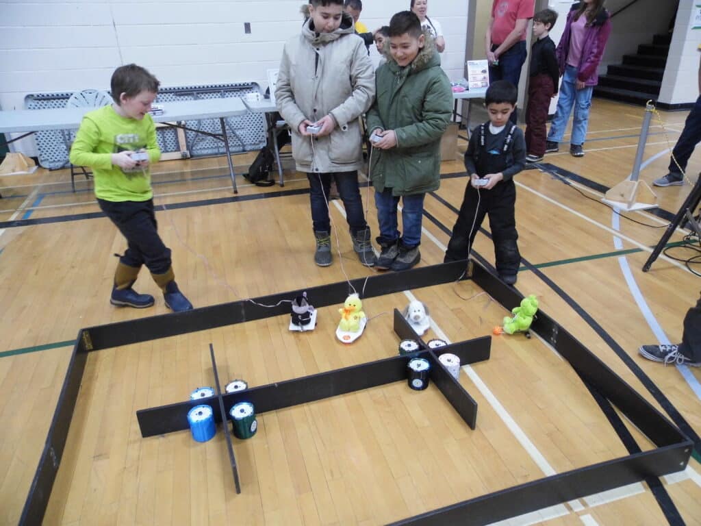 A group of kids pilot their tethered robo critters.